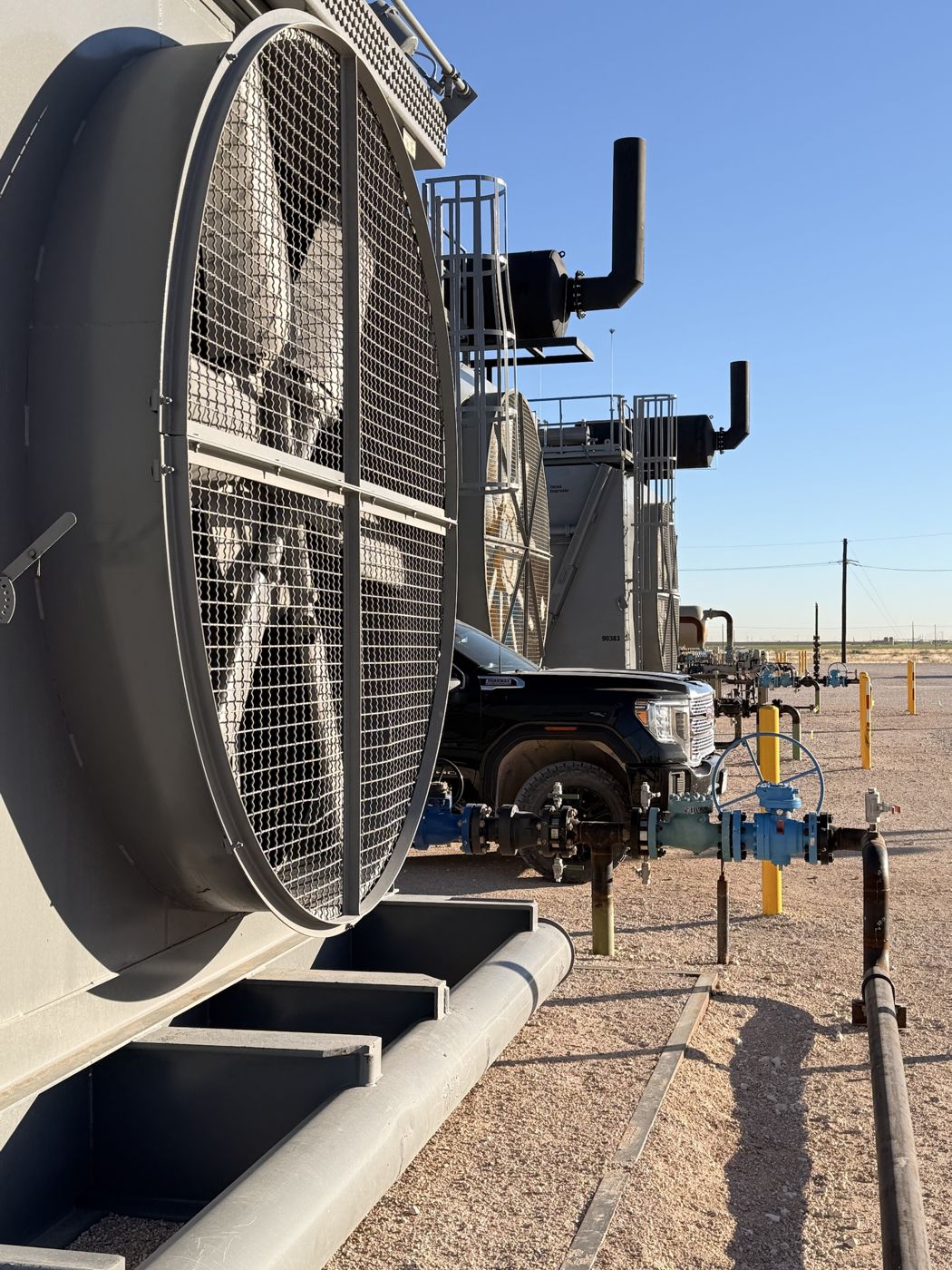 Compressor units lined up on location under clear sky